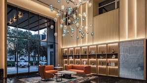 A modern lobby with a seating area, large windows, and a decorative light fixture. - Fairfield by Marriott Lijiang Ancient Town (Lijiang)
