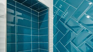 Une salle de bain avec une grande fenêtre et des murs recouverts de carreaux bleus.