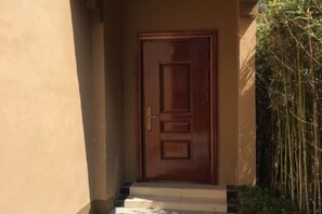 Una puerta de madera con manija de latón, que da a un tramo de escalones.