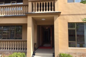 A building with a balcony, a red carpet entrance, and a window. - Longhai Hotel (Tanchang)
