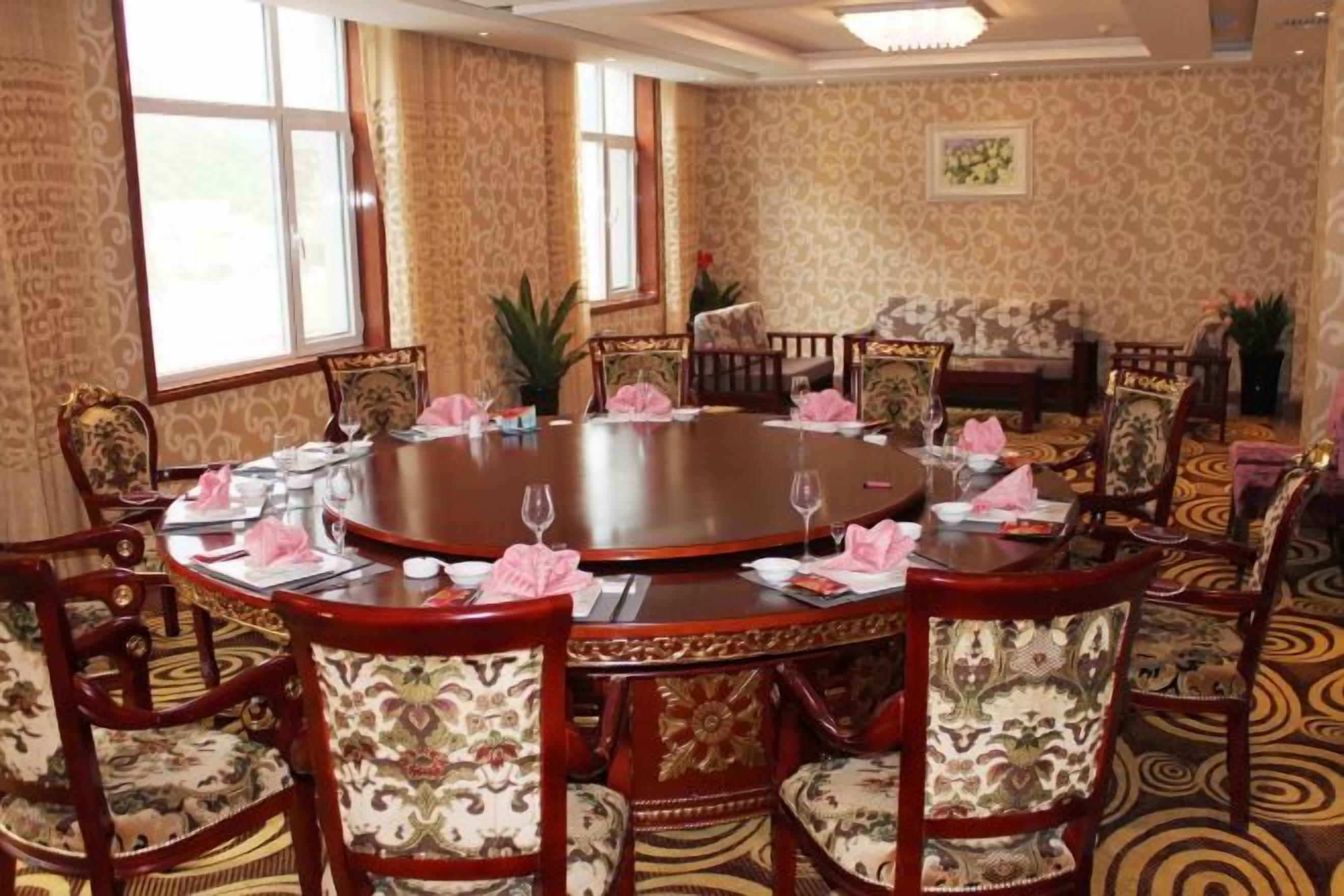 A conference room with a round table, chairs, and a sofa.