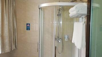 A glass-enclosed shower stall with a towel rack, a hand dryer, and a sign on the wall.