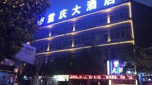 A hotel with a prominent sign reading "重庆大酒店" and a brightly lit facade. - Chongqing Hotel (Qinglong)