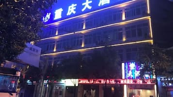 A hotel with a prominent sign, multiple floors, and a brightly lit facade.
