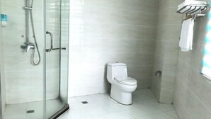 A small bathroom with a glass shower enclosure, a toilet, and a towel rack. - Chongqing Hotel (Qinglong)