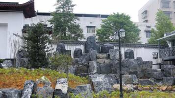 Un edificio tradicional con techo de tejas, paredes de piedra y una linterna de piedra.