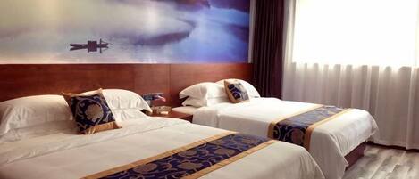 Habitación de hotel con dos camas, un cuadro grande en la pared y una ventana con cortinas.