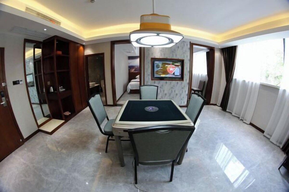 A conference room with a table, chairs, a television, and a large window.