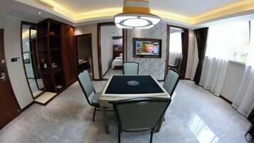 A conference room with a table, chairs, a television, and a large window.