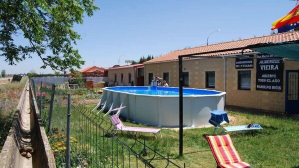 Una piscina al aire libre de temporada, sombrillas