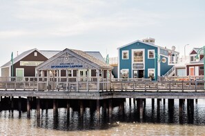 A wooden pier leading to a building labeled "SPINNAKERS LANDING" with a sign for "SUMMERSIDE SOUVENIRS & TRAVEL".