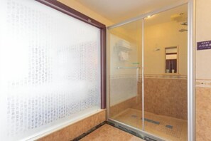 A hotel room with a sliding glass door leading to a shower area. - Dongfang Hotel (Rushan)