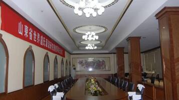 A conference room with a long table, chairs, and a chandelier.