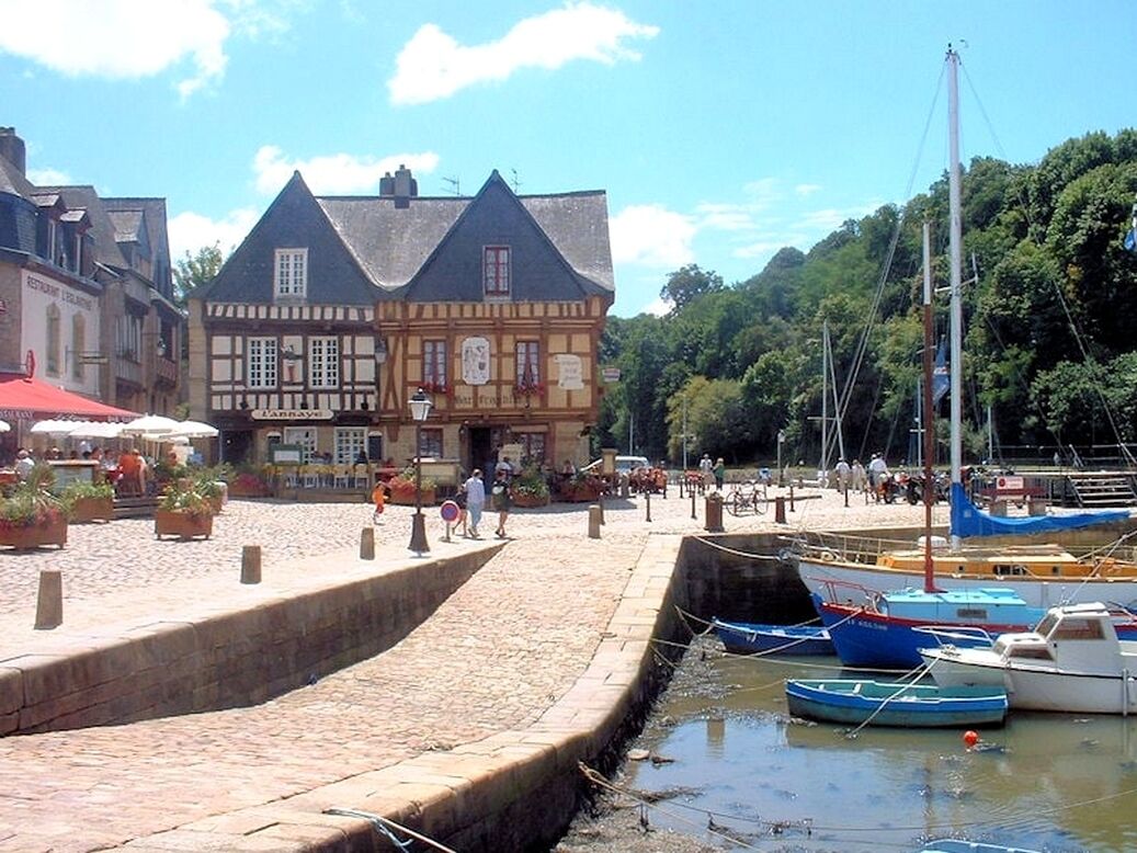 Zona ribereña con un edificio tradicional, un canal y barcos.