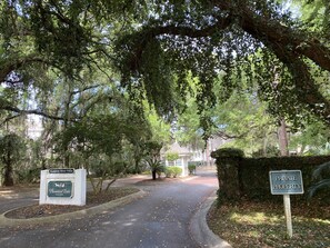 Un sentiero conduce a un'area recintata con cartelli che indicano 'Hampton River Villas' e 'Proprietà Privata'.