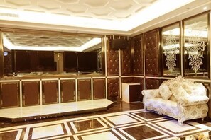 A lobby with a stage, a sofa, and a large mirror.