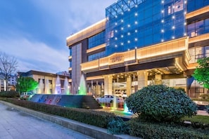 A modern hotel with a glass facade, a central fountain, and a well-maintained garden. - Tianshui Hotel (Tianshui)