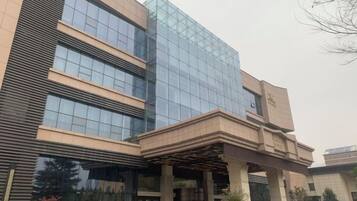 A modern building with a glass facade and a covered entrance area.