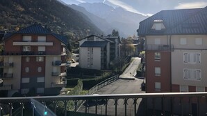 Ein Wohngebiet mit Gebäuden, einer Straße und Bergen im Hintergrund.