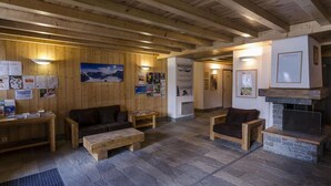 Ein Holzinnenraum mit Kamin, Sitzgelegenheit und Informationsplakaten.