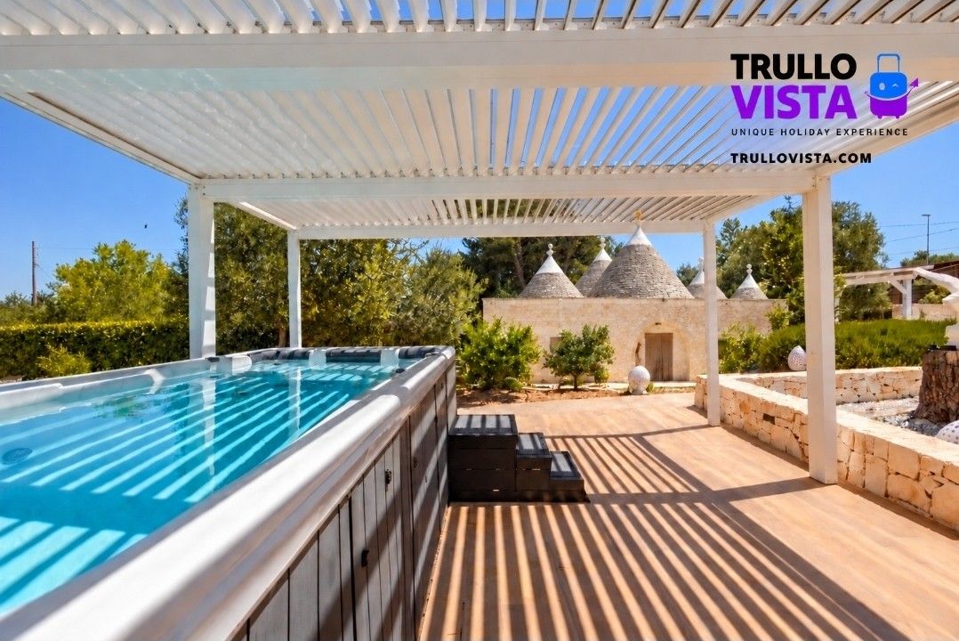Relax under the pergola beside the spa with charming trulli views