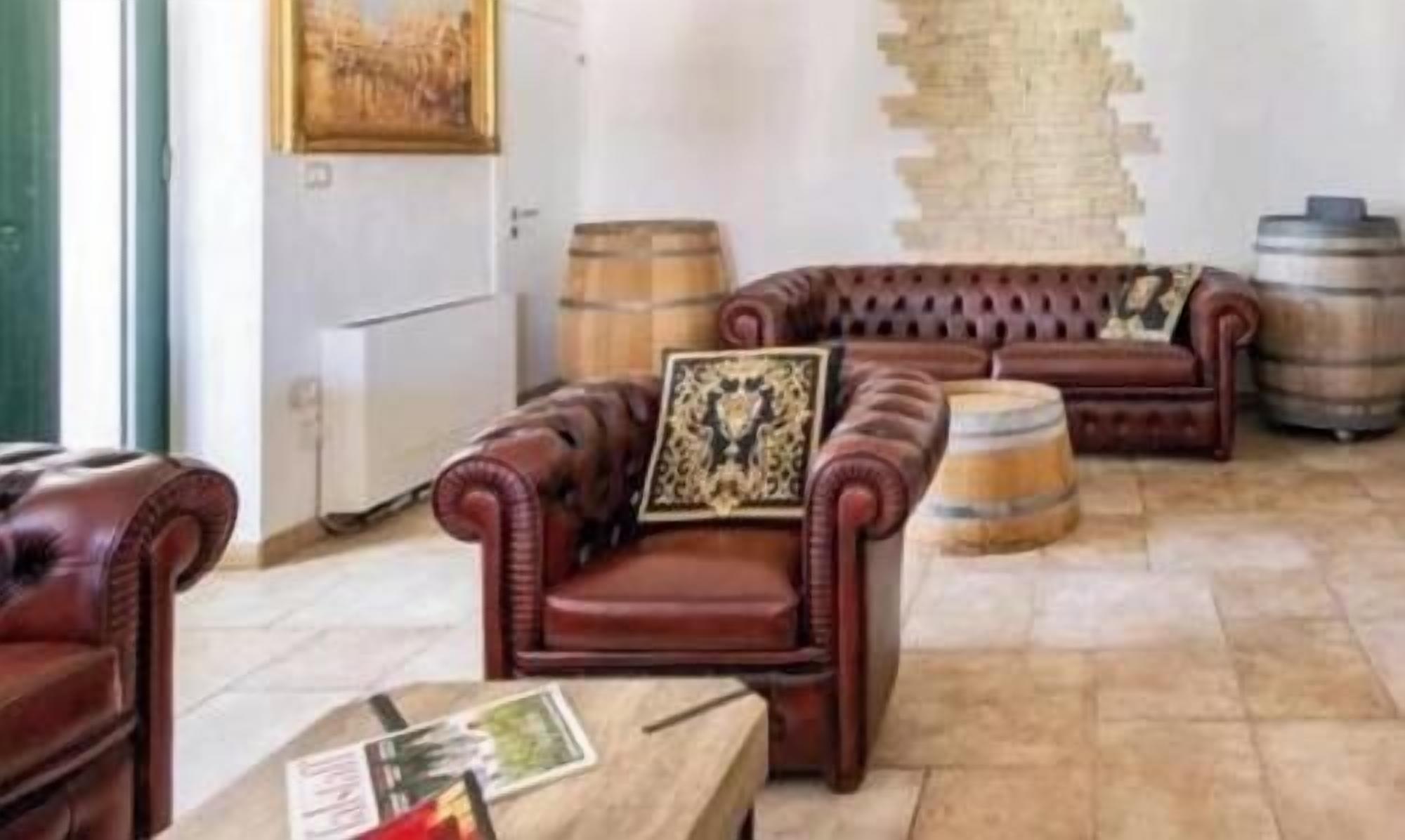 Une pièce avec des canapés en cuir, une table basse en bois et un mur au style rustique.
