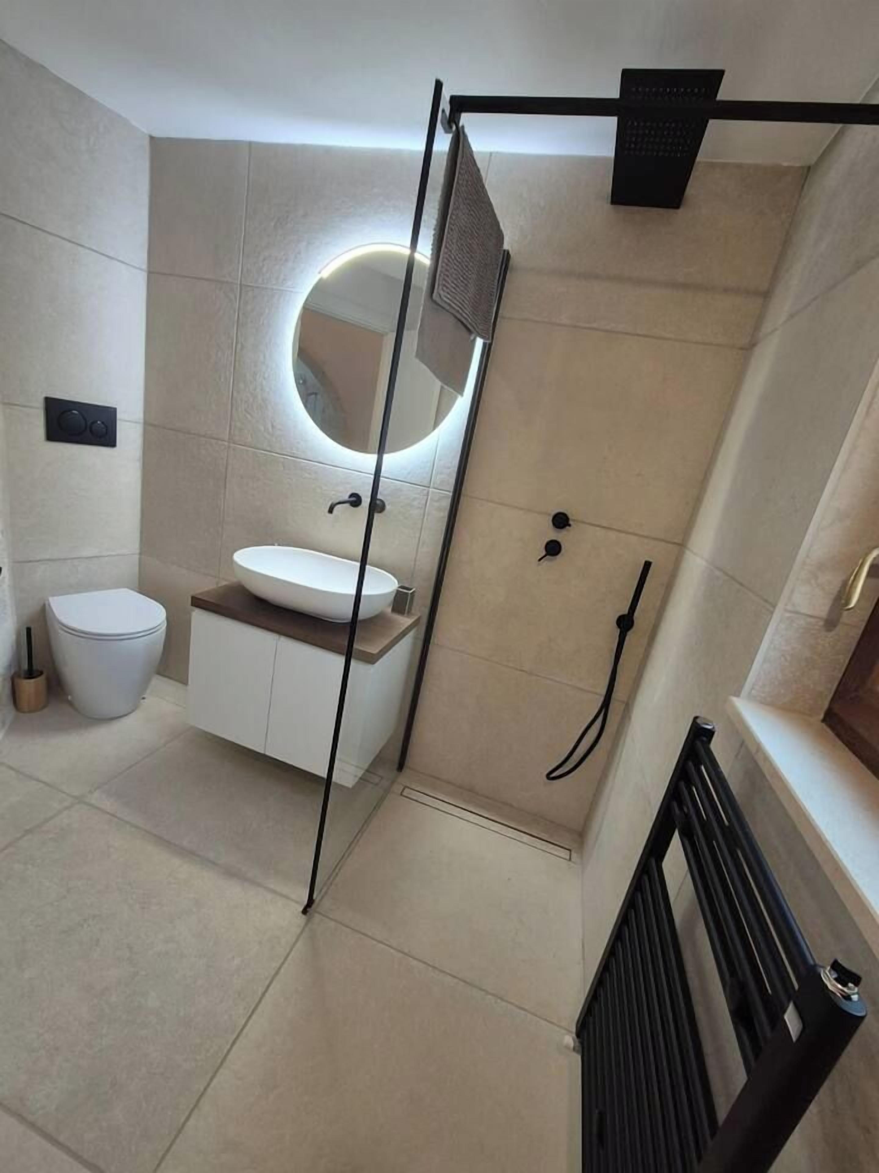 Une salle de bain moderne équipée de toilettes, d’un lavabo et d’un espace douche.