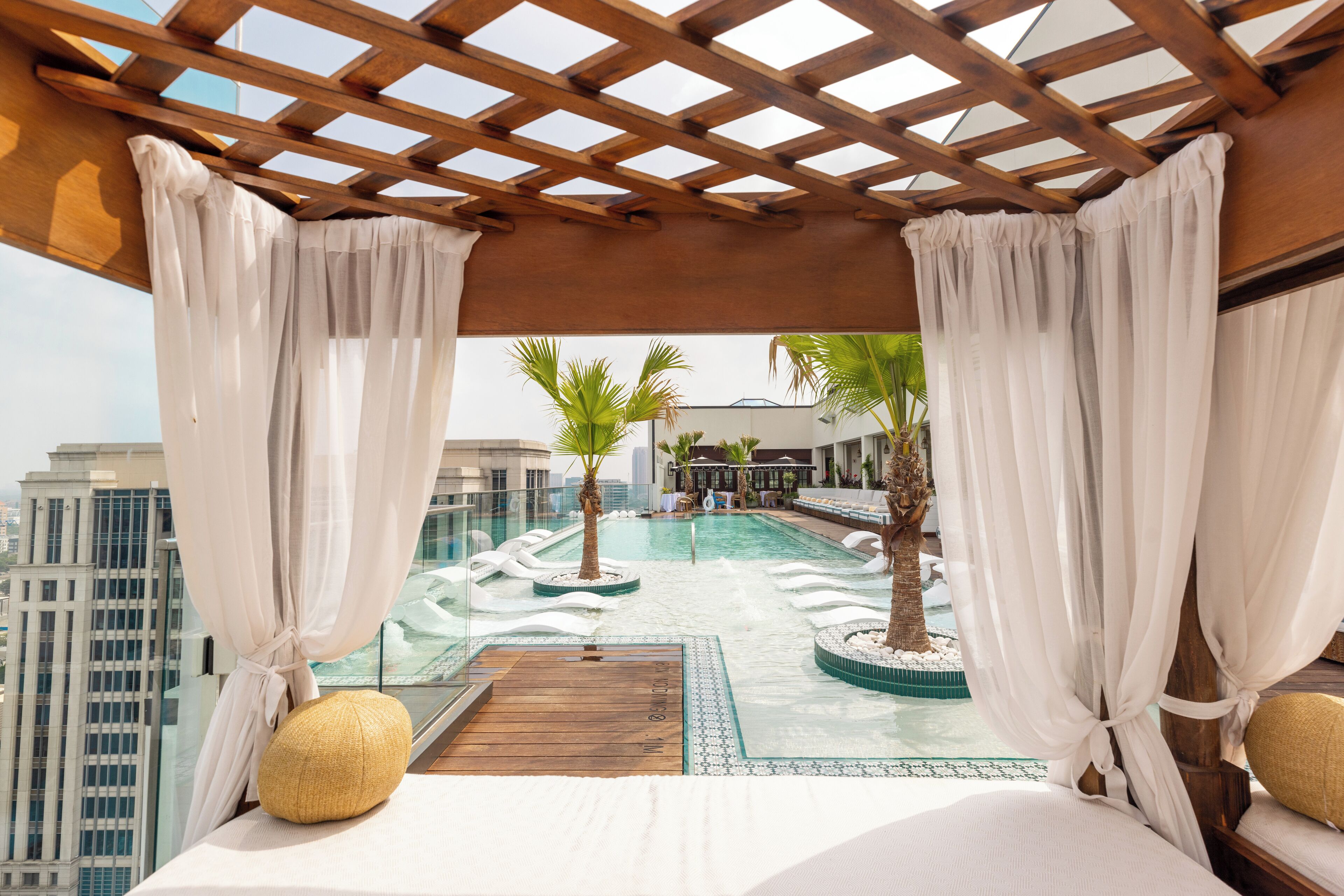 Una piscina al aire libre, sombrillas, sillones reclinables de piscina