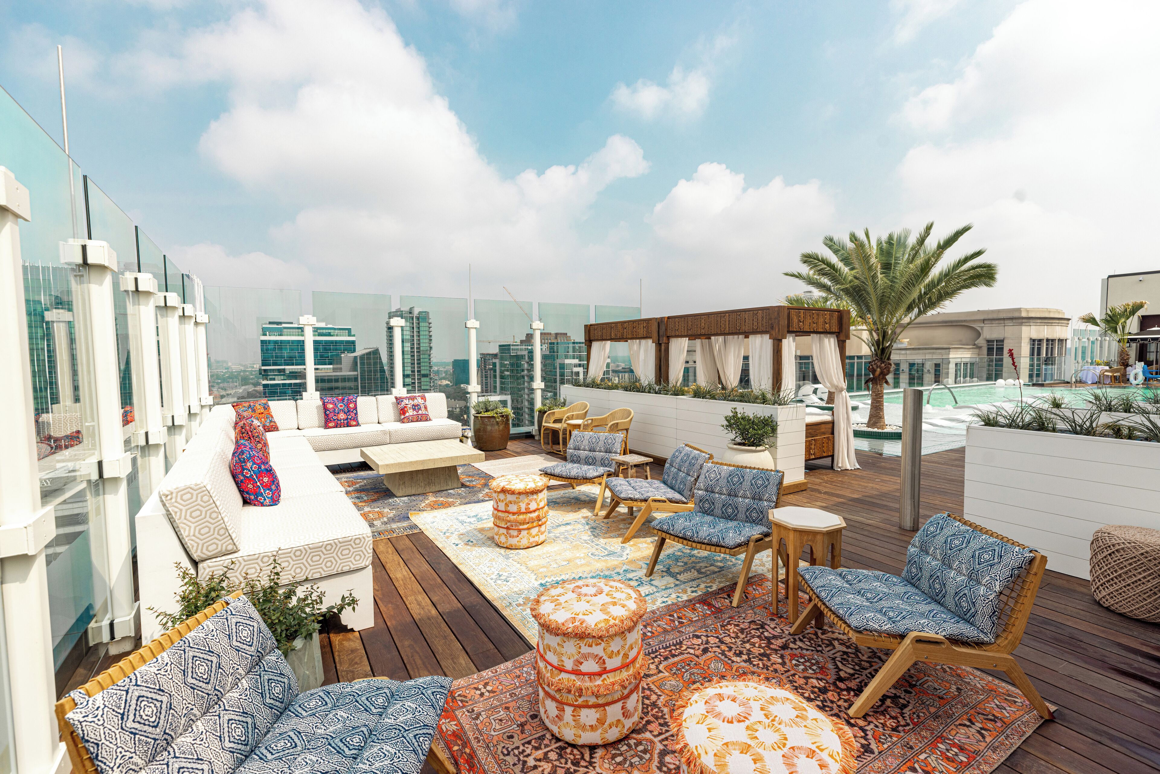 Une terrasse sur le toit avec des sièges extérieurs, une plateforme en bois et une vue panoramique sur la ville.