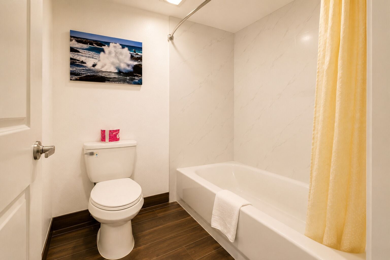 A bathroom with a toilet, a bathtub, and a shower curtain.