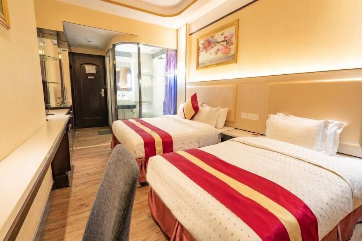 Una habitación de hotel con dos camas, un escritorio y una silla.