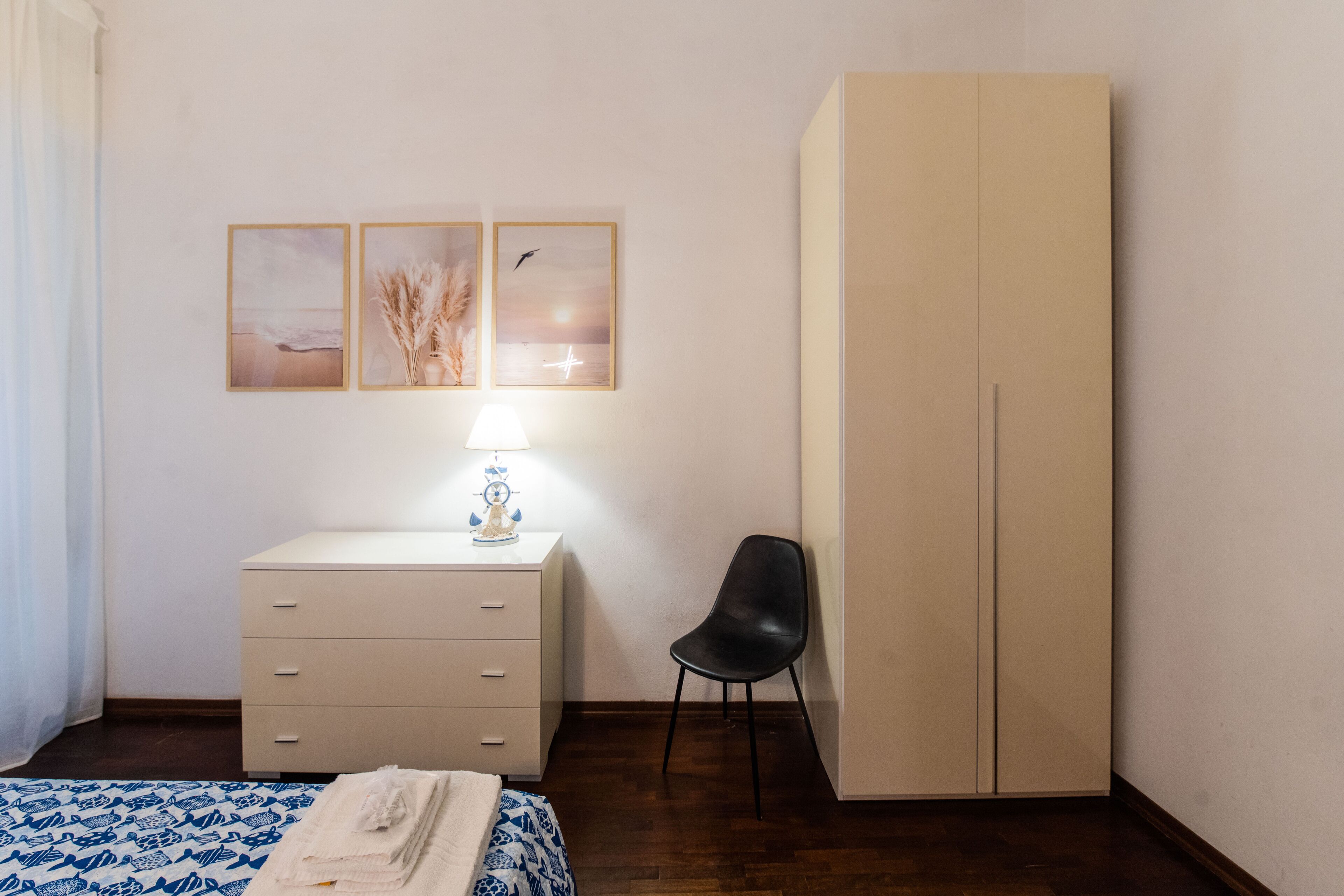 A bedroom with a bed, a dresser, a chair, and a wardrobe.