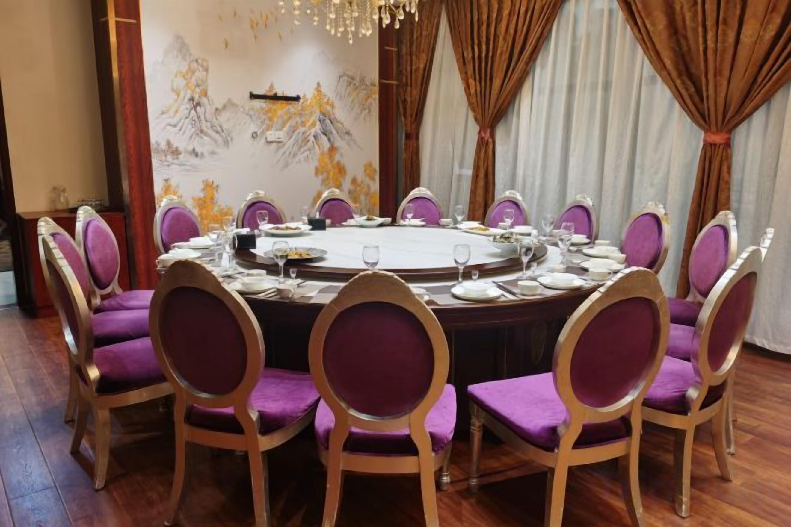 Una mesa redonda de comedor con sillas, preparada para una comida.