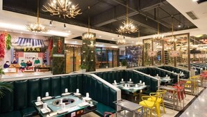 Un restaurante con cabinas y mesas, algunas con sillas, y una barra con la carta.