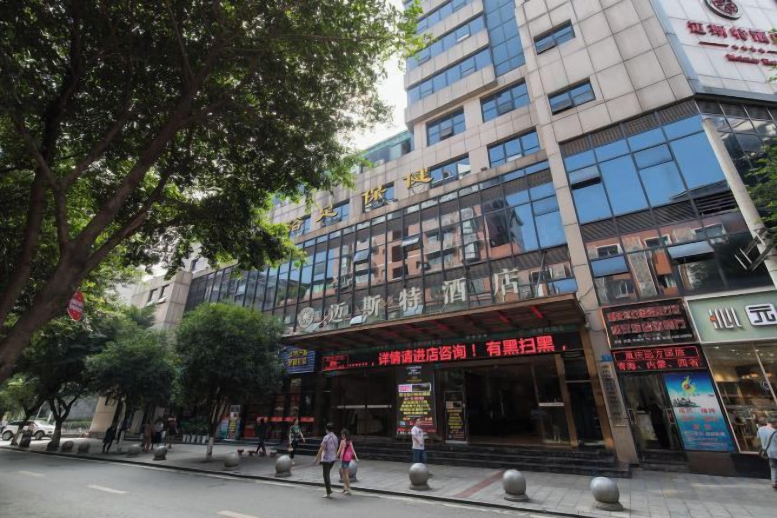 A multi-story hotel with a prominent entrance, signage, and a pedestrian walkway.