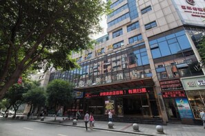 A multi-story hotel with a prominent entrance, signage, and a pedestrian walkway. - Meister Hotel (Chongqing)