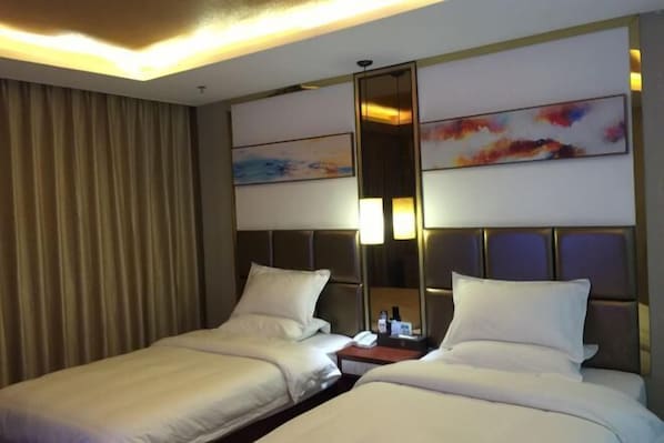 A hotel room with two beds, a large mirror, and artwork on the wall. - Guanghe Business Hotel (Shaoguan Fengcai Experimental School) (Shaoguan)