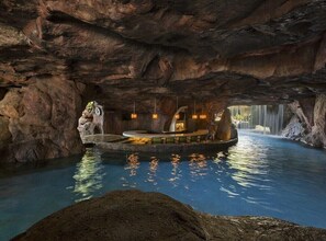 Une formation rocheuse naturelle dotée d’une piscine et d’un espace aménagé pour s’asseoir.
