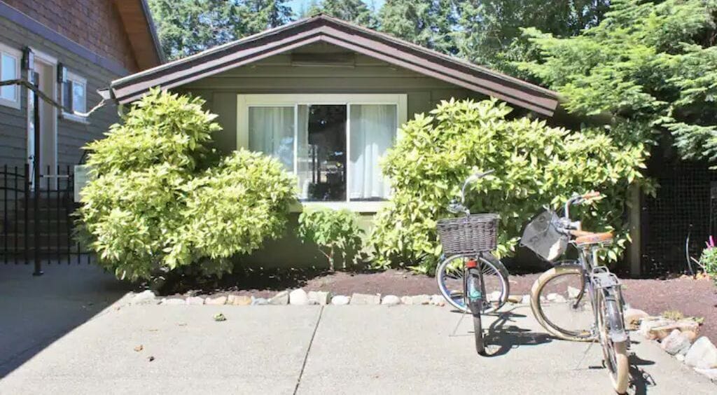 A house with a front yard, a bicycle, and a small garden.