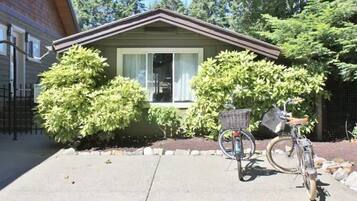 A house with a front yard, a bicycle, and a small garden.