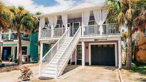 Une maison à deux étages avec un porche couvert, un escalier et un garage.