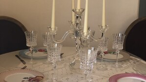 A dining table set with crystal glassware, white plates, and a candelabra with lit candles. - Small warm house. (Le Château-d'Oléron)