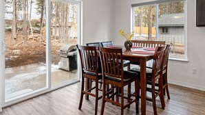 Un comedor con una mesa y sillas, ventanas amplias y vistas al exterior.