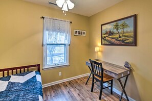 A bedroom with a bed, a desk, a chair, a window with curtains, a painting on the wall, and a ceiling fan. - Pet-Friendly Extended Stay Walk to Delavan Lake (Delavan)