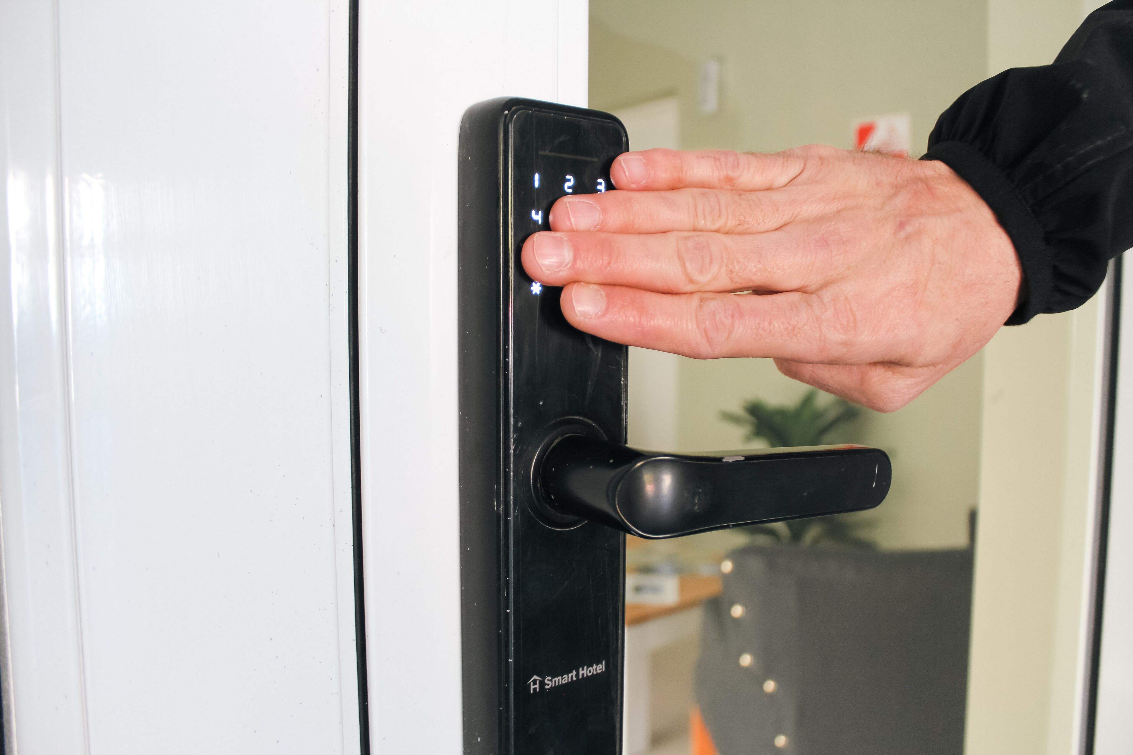 A hand operating a smart hotel door lock.