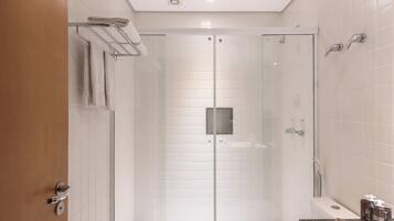 A modern bathroom with a glass-enclosed shower, a toilet, and a sink with a countertop.