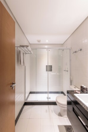 A modern bathroom with a glass-enclosed shower, a toilet, and a sink with a countertop. - DELPLAZA Timbiras São Paulo (São Paulo)