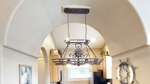 A kitchen with granite countertops, a hanging light fixture, and a ship's wheel decoration. - Paradise Cove Walk-in Log Cabin by Silver Dollar City & Table Rock Lake! (Branson)