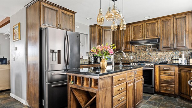A kitchen with wooden cabinets, stainless steel appliances, and a tiled backsplash. - Stylish Chalet with Hot Tub and Jacuzzi! (Lake Arrowhead)