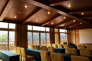 A conference room with tables and chairs, large windows, and a projector screen. - Longshui Lake Dalong Bay Hotel (Chongqing)